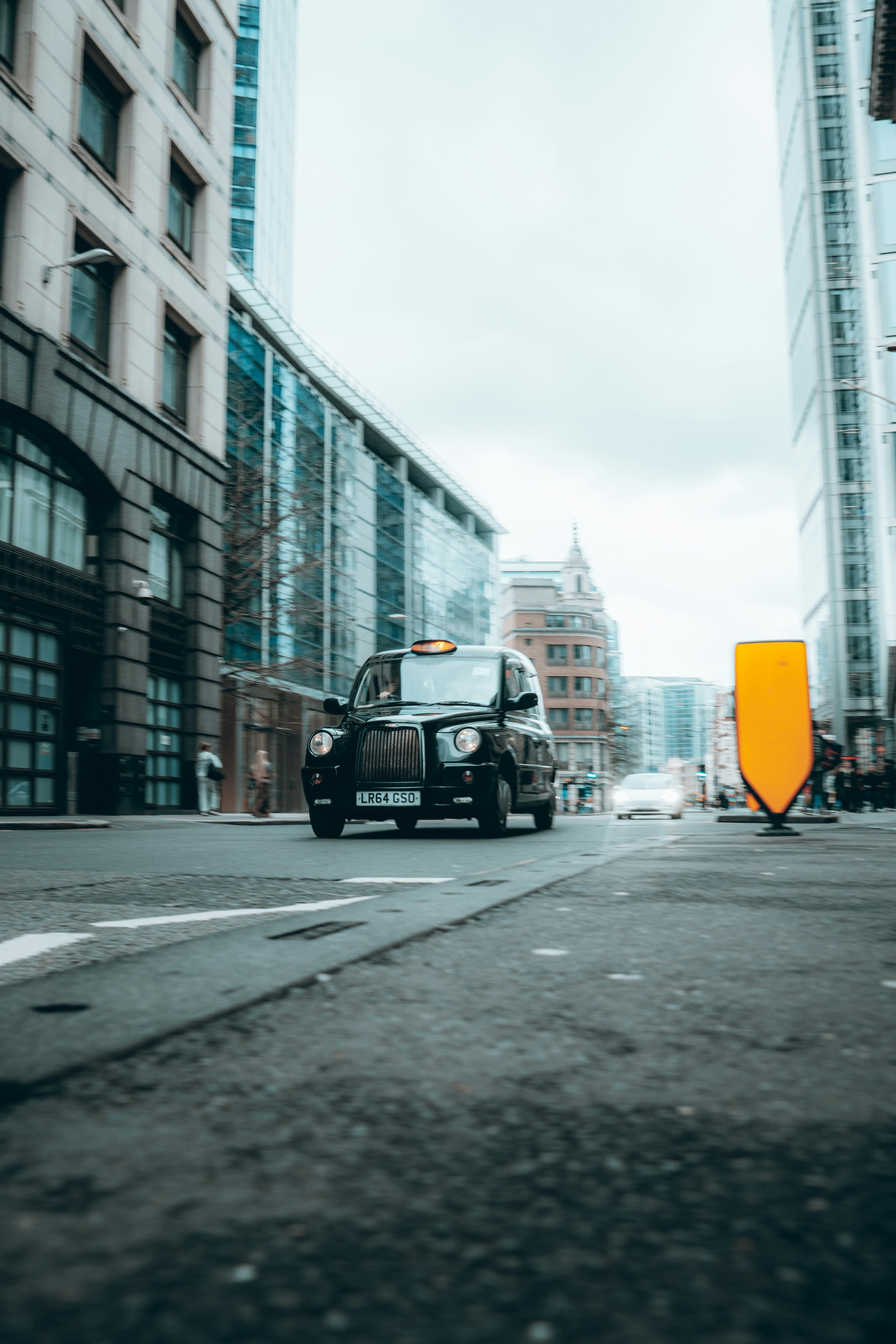 A London street with a black taxi in motion